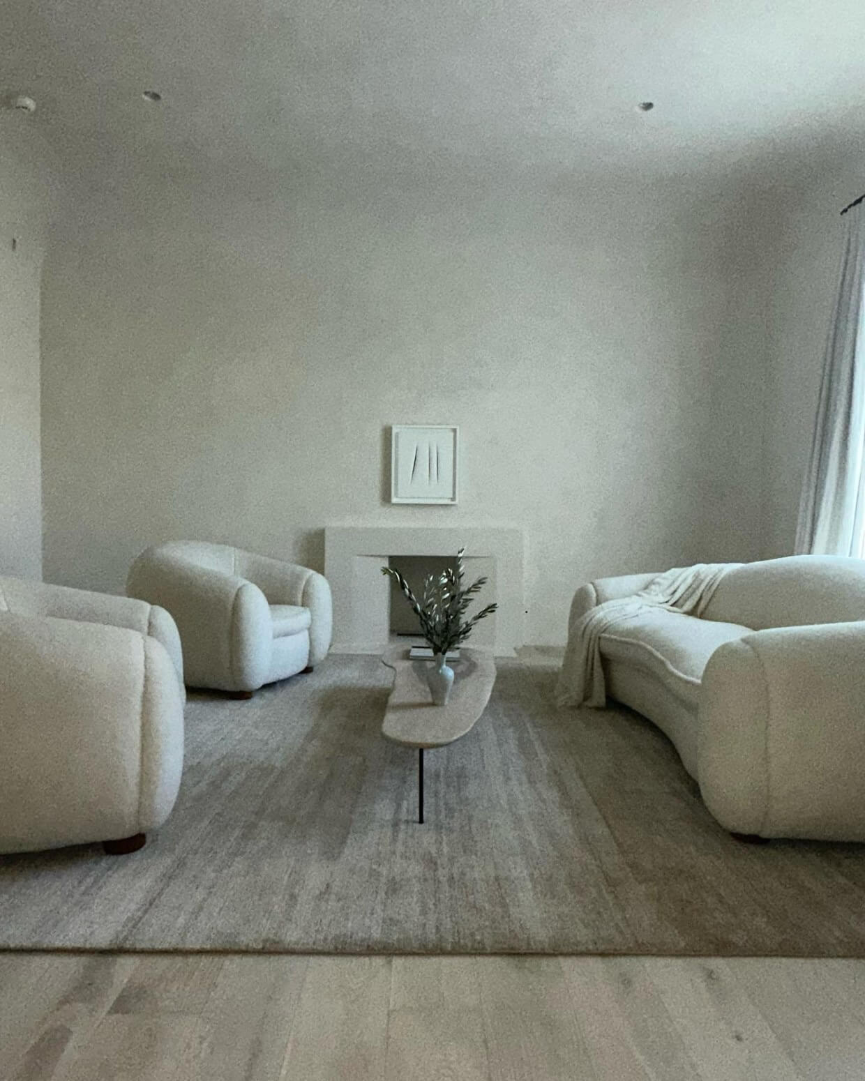 Kim's living room, which features bare walls and a neutral, minimalist decor